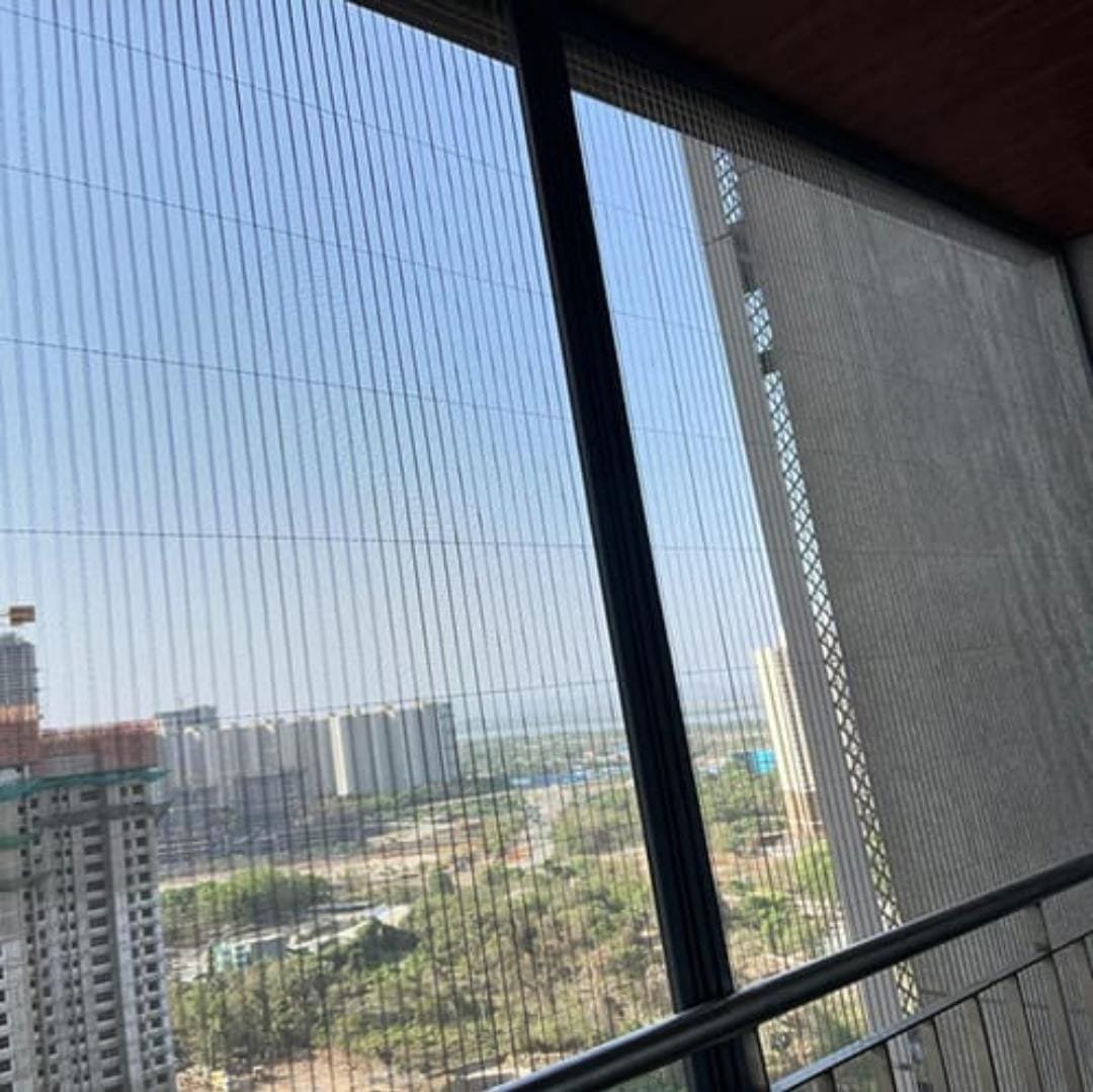 Pleated mesh screen on a high-rise balcony overlooking the city